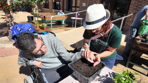 Participantes trabajando la motricidad fina a través de la siembra de semillas.